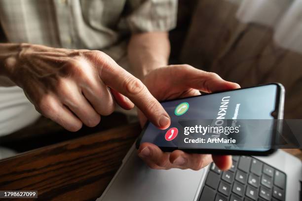 senior man refuses to answer to a call from unknown number. scam and fraud prevention with smartphone concept. - roubo empresarial imagens e fotografias de stock