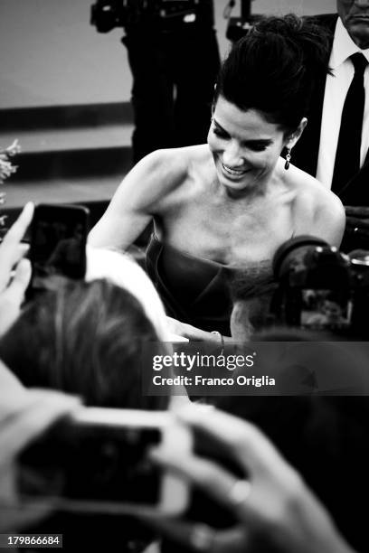 Actress Sandra Bullock signs autographs during the Opening Ceremony And 'Gravity' Premiere at Palazzo del Cinema on August 28, 2013 in Venice, Italy.