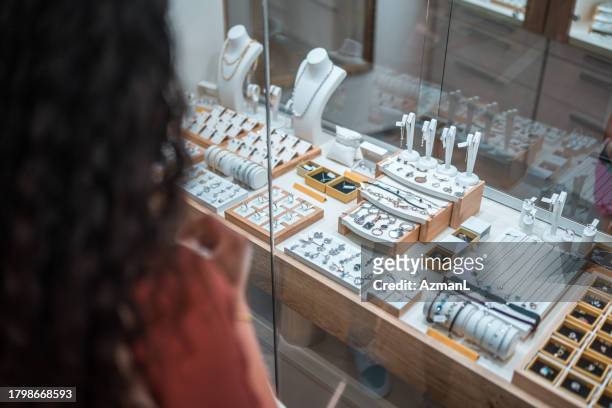 hispanic female window shopping at the jewelry store - silver metal stock pictures, royalty-free photos & images