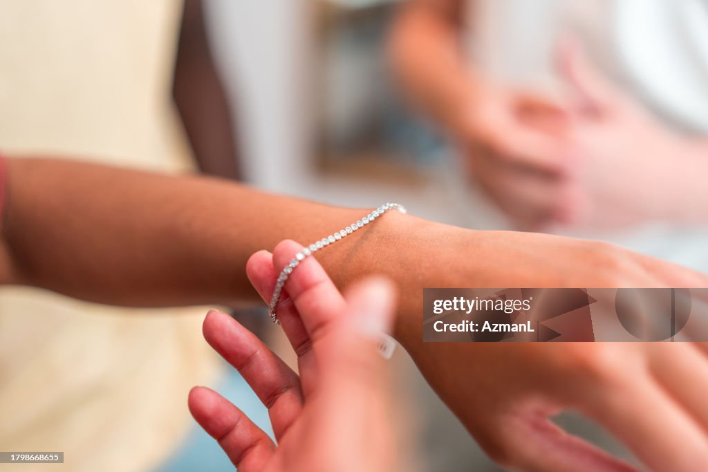 Hispanische Frau probiert ein Armband im Juweliergeschäft an