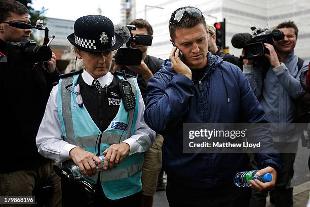 Stephen Lennon aka Tommy Robinson, leader of the English Defence League, discusses plans with a police liasion officer before the group march to...