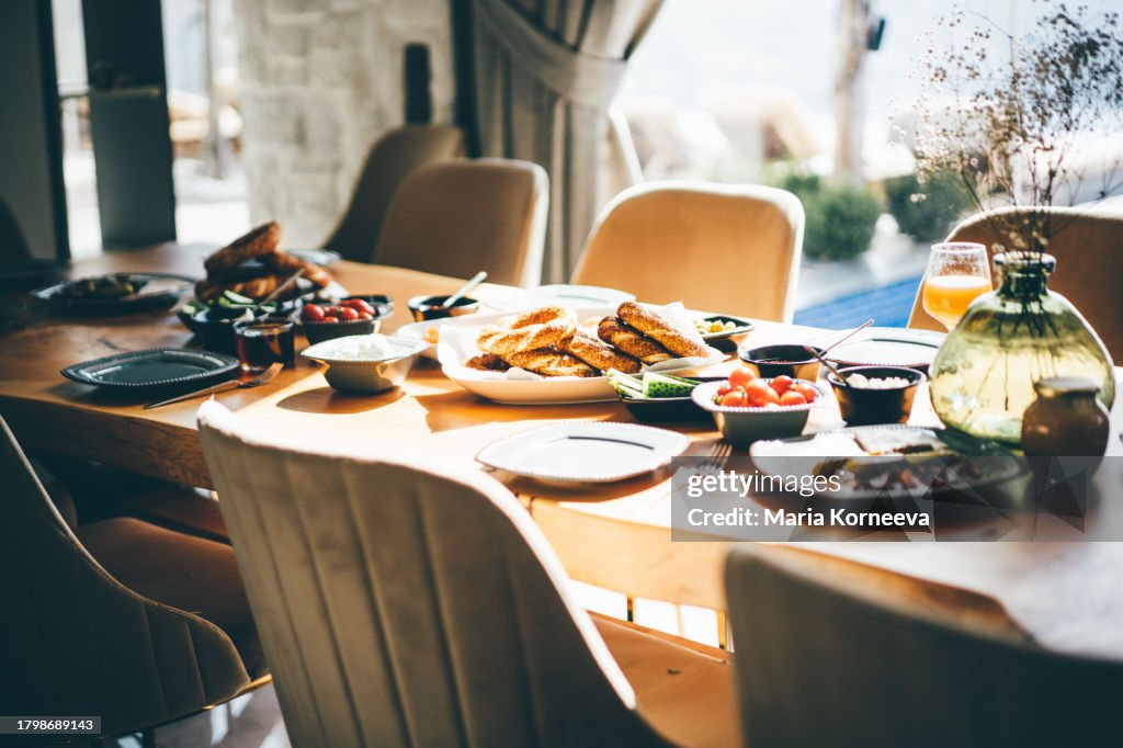 The table is set for breakfast for a large company.
