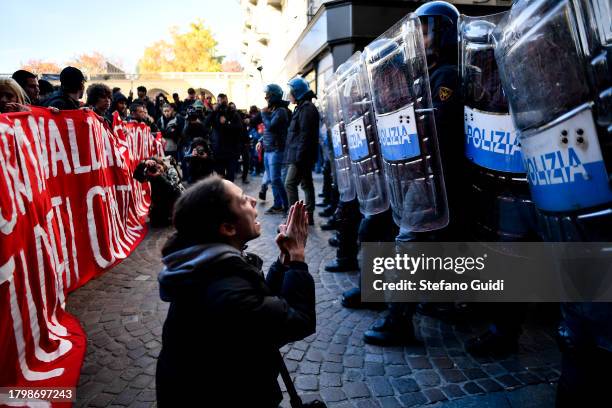 Student prays in front of riot police during the student protest demonstration against the Italian Government on November 17, 2023 in Turin, Italy....