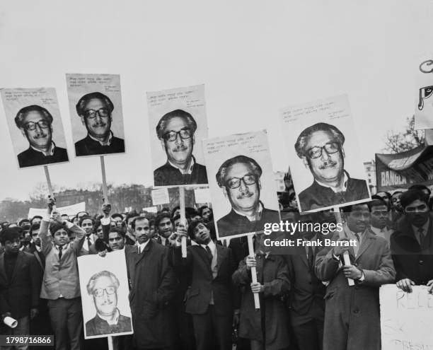 Bangladesh supporters holding placards with images of Bangladeshi politician Sheikh Mujibur Rahman, as they to Downing Street, where they will hand...