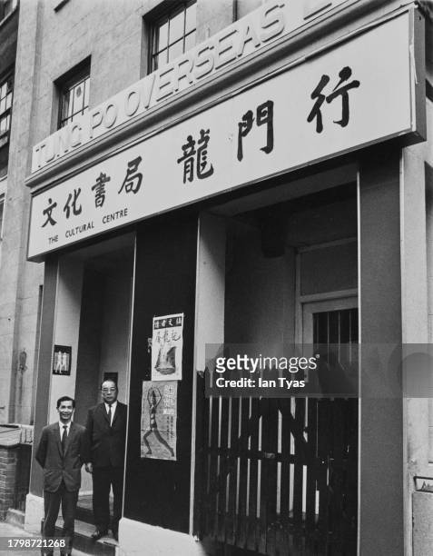 Two men standing at the entrance to a Chinese Cultural Centre - the sign above reads 'Tung Po Overseas' - in London, England, circa 1955.
