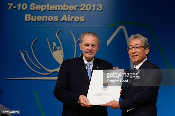 President Jacques Rogge delivers a diploma to president of the Japanese Olympic Committee and Tokyo 2020 delegation, Tsunekazu Takeda, after the...