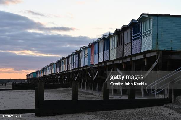 General view of beach huts on the beach at dusk on November 15, 2023 in Frinton-on-Sea, United Kingdom.