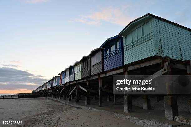 General view of beach huts on the beach at dusk on November 15, 2023 in Frinton-on-Sea, United Kingdom.