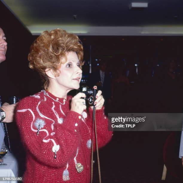View of American Country & Pop singer Brenda Lee as she holds a camera, London, England, April 5, 1985.