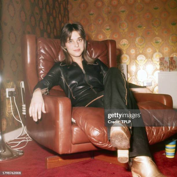 Portrait of American Rock musician and actress Suzi Quatro in an armchair, London, England, 1976.