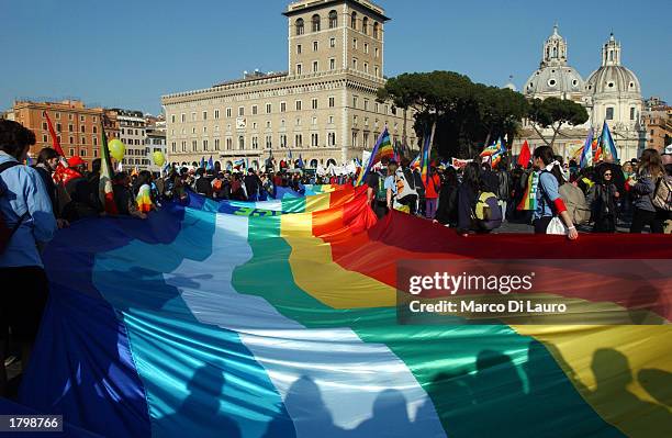 Peace demonstrators hold a rainbow peace flag as they participate in an antiwar protest in Venezia Square February 15, 2003 in downtown Rome, Italy....
