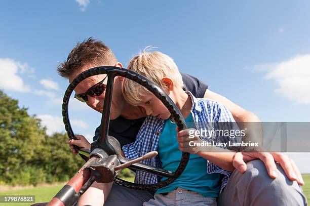 father teaching his son to drive a tractor - friesland stock pictures, royalty-free photos & images