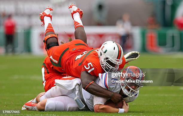 Jeff Driskel of the Florida Gators is tackled by Shayon Green of the Miami Hurricanes during a game at Sun Life Stadium on September 7, 2013 in Miami...