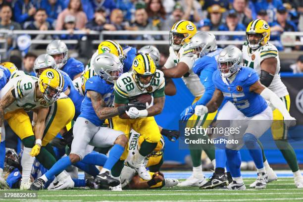 Green Bay Packers running back AJ Dillon is tackled by Detroit Lions safety Brian Branch during an NFL Thanksgiving Day football game between the...