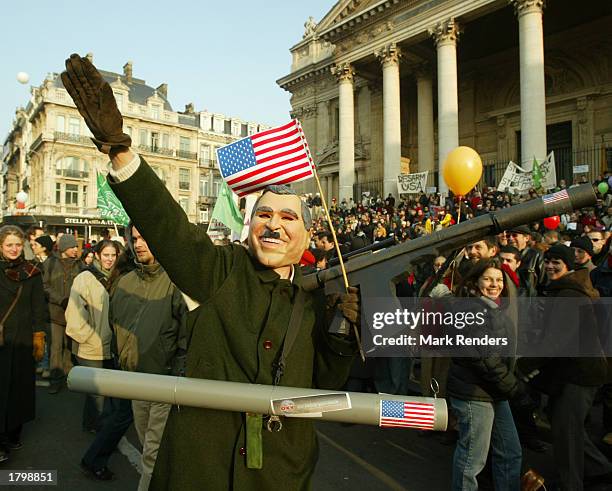 An activist dressed as U.S. President George W. Bush marches through the streets of Brussels with other protesters as they participate in an antiwar...