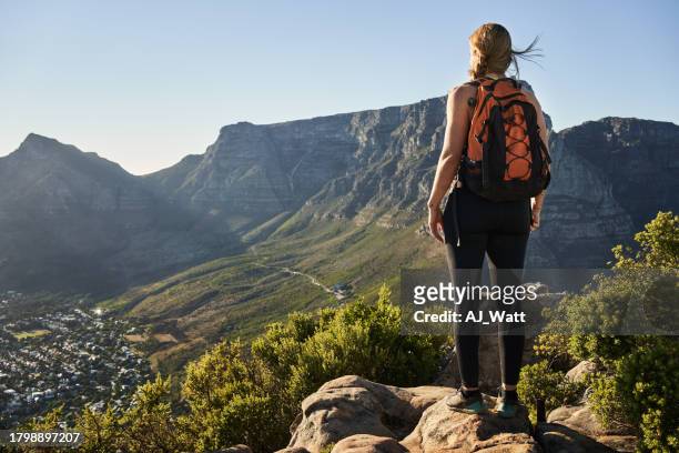 woman hiker standing on mountain trail and looking at the scenery - cape peninsula stock pictures, royalty-free photos & images