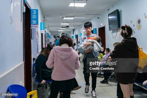 Parents with children suffering from respiratory diseases line up at a children's hospital in Chongqing, China, November 23, 2023.