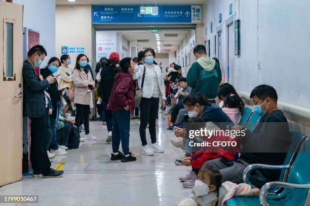 Parents with children suffering from respiratory diseases line up at a children's hospital in Chongqing, China, November 23, 2023.