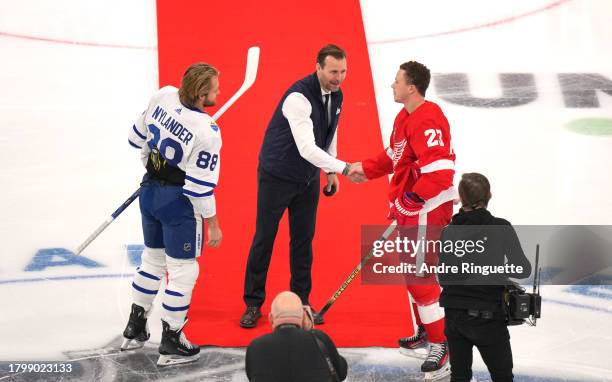 Anders Salming shakes the hand of Lucas Raymond of the Detroit Red Wings after the ceremonial opening face-off before the start of the 2023 NHL...