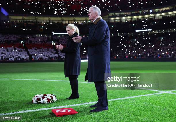 In this handout image provided by The FA, Sir Geoff Hurst and Debbie Hewitt lay a wreath on the pitch in remembrance of Sir Bobby Charlton CBE prior...