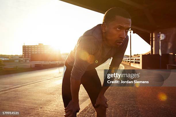 a man running in the city. - hand on knee stock pictures, royalty-free photos & images