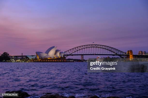 hafen von sydney bei sonnenuntergang - hafenbrücke von sydney stock-fotos und bilder