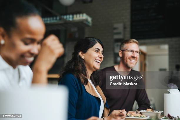 happy male and female colleagues having lunch together in restaurant - mittagspause stock-fotos und bilder