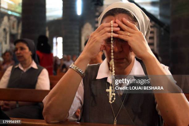 Nun attends a prayer vigil for peace at the Lady of Dormition, the Melkite Greek Catholic patriarchal cathedral in the Old City of Damascus, on...