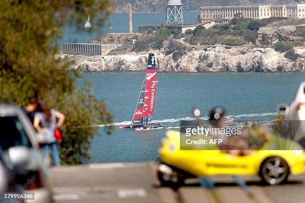 Passing Alcatraz Island, Emirates Team New Zealand's AC72 catamaran heads to the competition course shortly before facing Oracle Team USA in the...
