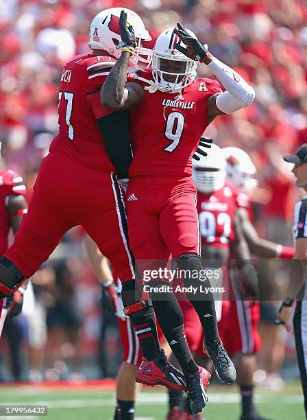 Abraham Garcia of the Louisville Cardinals celebrates with Devante Parker after Parker caught a touchdown pass during the game against the Eastern...