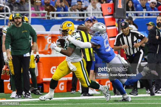 Green Bay Packers running back AJ Dillon runs with the ball while trying to avoid being tackled by Detroit Lions linebacker Derrick Barnes during a...