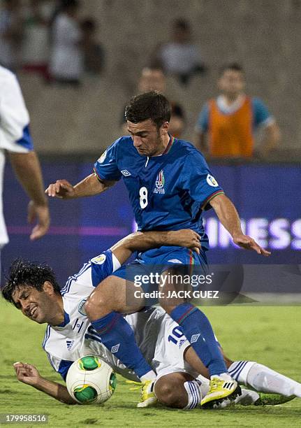 Israels forward Elyaniv Barda falls to the ground as he vies with Azerbaijan's Gara Garayev during the FIFA 2014 World Cup European zone qualifying...