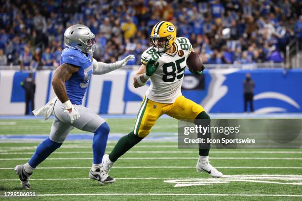 Green Bay Packers tight end Tucker Kraft runs with the ball after catching a pass while trying to avoid being tackled by Detroit Lions linebacker...