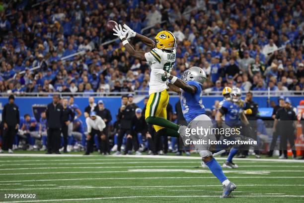 Green Bay Packers wide receiver Romeo Doubs leaps to catch a pass against Detroit Lions cornerback Jerry Jacobs during a traditional Thanksgiving Day...