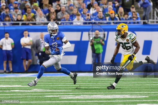 Detroit Lions wide receiver Jameson Williams runs with the ball after catching a pass while Green Bay Packers cornerback Corey Ballentine chases...