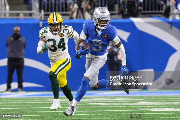 Detroit Lions wide receiver Jameson Williams runs with the ball after catching a pass while Green Bay Packers safety Jonathan Owens chases after him...