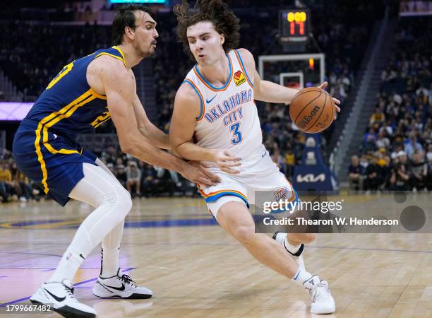 Josh Giddey of the Oklahoma City Thunder looks to drive to the basket on Dario Saric of the Golden State Warriors during the first quarter at Chase...