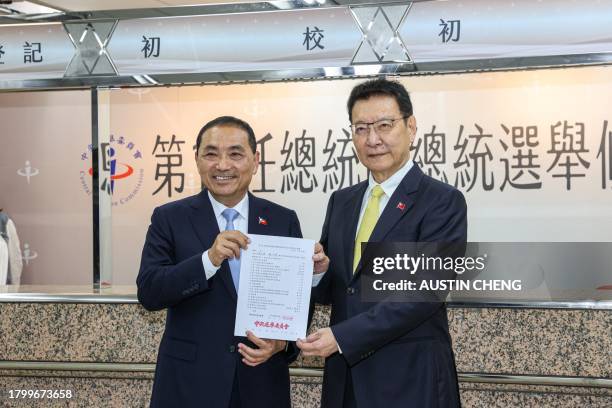 Hou Yu-ih , Taiwanese presidential candidate from the main opposition party Kuomintang , and his KMT running mate Jaw Shaw-kong display a certificate...