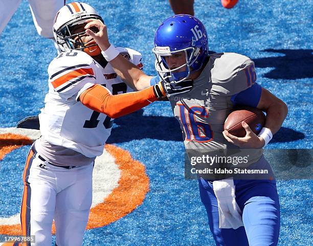 Boise State quarterback Joe Southwick, right, fights off Tennessee-Martin defensive back Leon Carlton III in the first half at Bronco Stadium in...