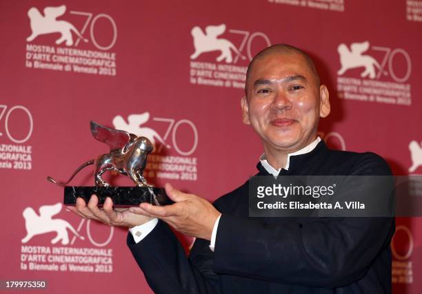 Director Tsai Ming-liang poses with the Grand Jury Prize he received for his movie 'Jiaoyou' as he attends the Award Winners Photocall during the...