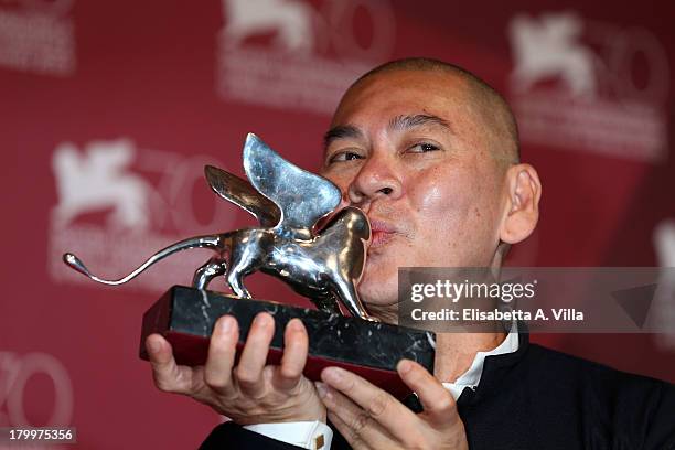 Director Tsai Ming-liang poses with the Grand Jury Prize he received for his movie 'Jiaoyou' as he attends the Award Winners Photocall during the...