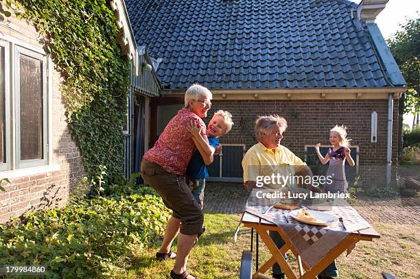 grandchildren running into arms of grandparents - rooftop farm stock pictures, royalty-free photos & images