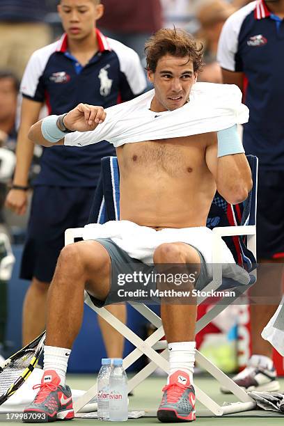 Rafael Nadal of Spain puts on his shirt during a break in play in his men's singles semifinal match against Richard Gasquet of France on Day Thirteen...