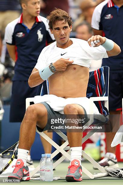 Rafael Nadal of Spain puts on his shirt during a break in play in his men's singles semifinal match against Richard Gasquet of France on Day Thirteen...