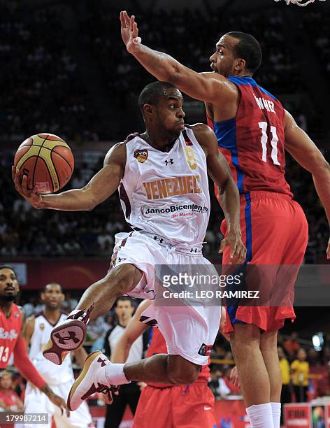Venezuelan basketball player David Cubillan vies for the ball with Puerto Rican Ricardo Sanchez during their Spain 2014 FIBA World Cup qualifier...