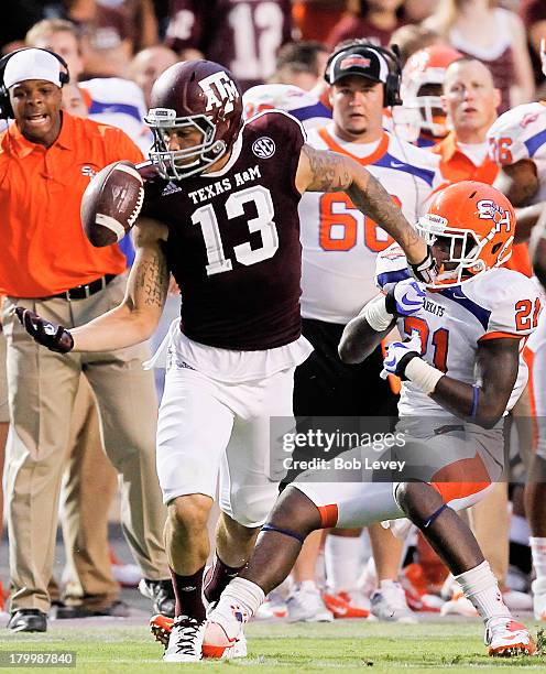 Mike Evans of the Texas A&M Aggies juggles but gains control of the ball as he is defended by Desmond Fite of the Sam Houston State Bearkats in the...