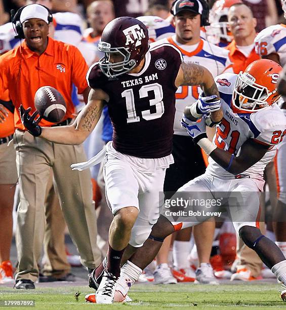 Mike Evans of the Texas A&M Aggies juggles but gains control of the ball as he is defended by Desmond Fite of the Sam Houston State Bearkats in the...