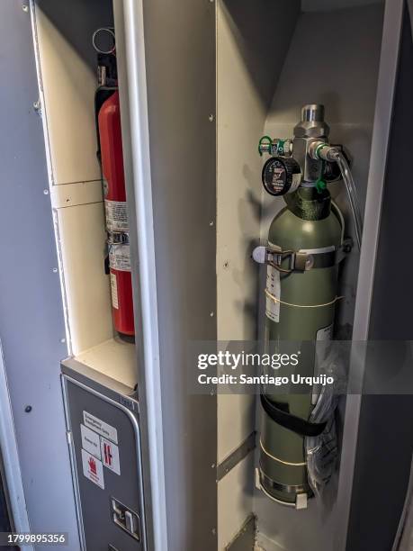fire extinguishers at door of an airplane - artículo de emergencia fotografías e imágenes de stock