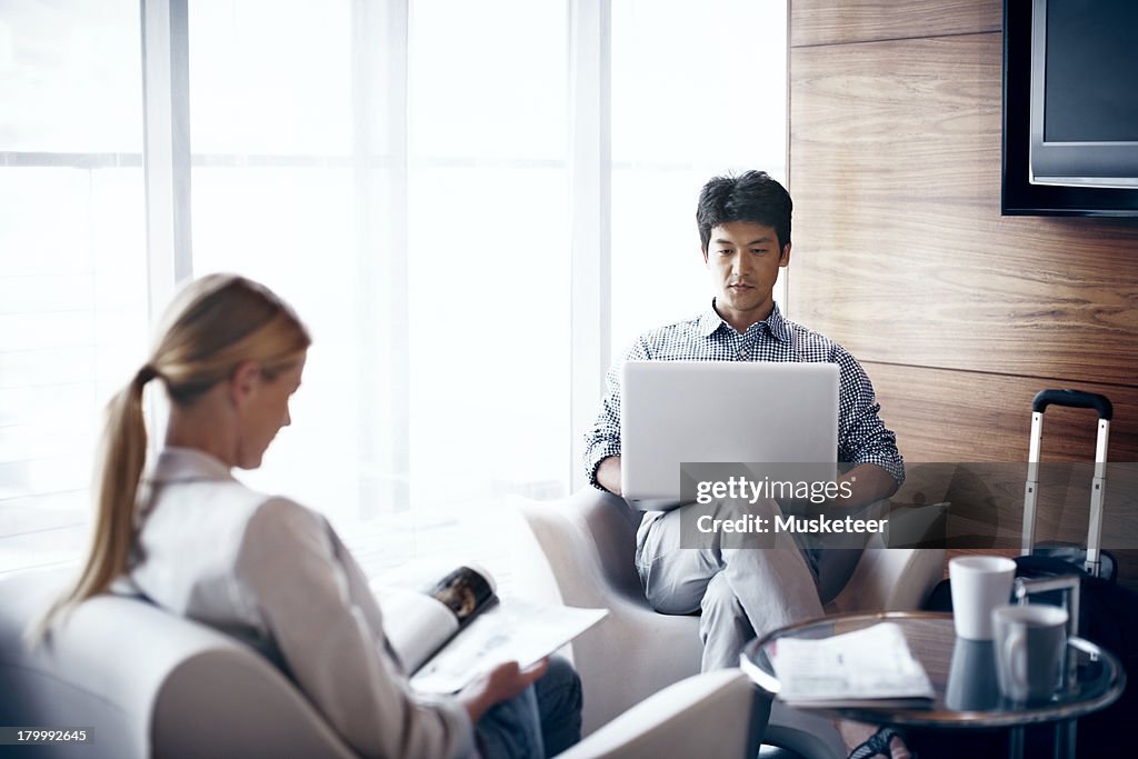 Two people relaxing in an airport lounge