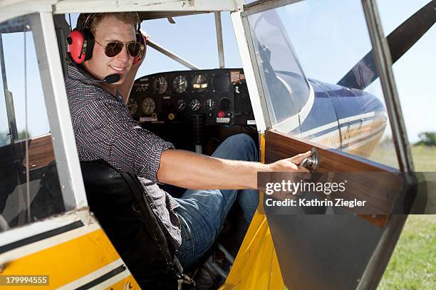 young pilot in a propeller-driven plane - small plane stock pictures, royalty-free photos & images